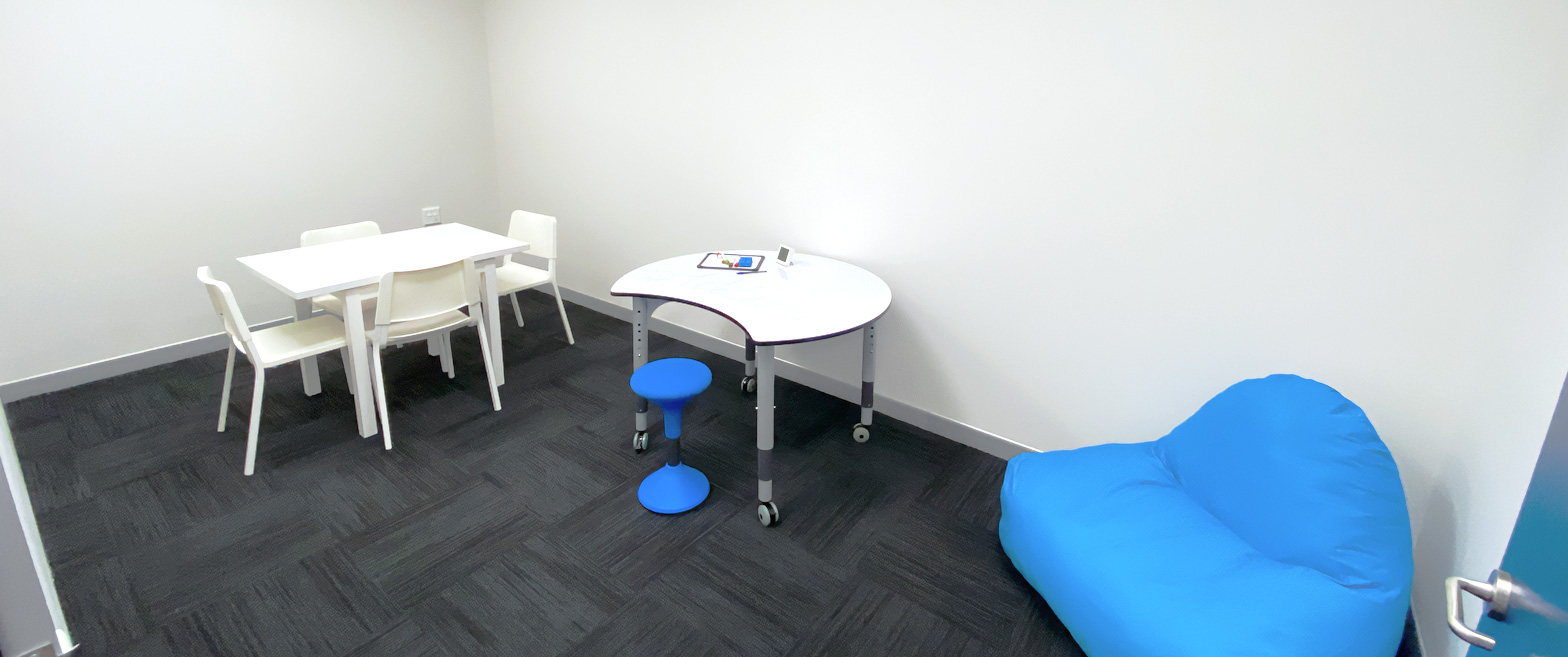 An Allied Health room with a four-seater table, an activity table and a blue bean bag