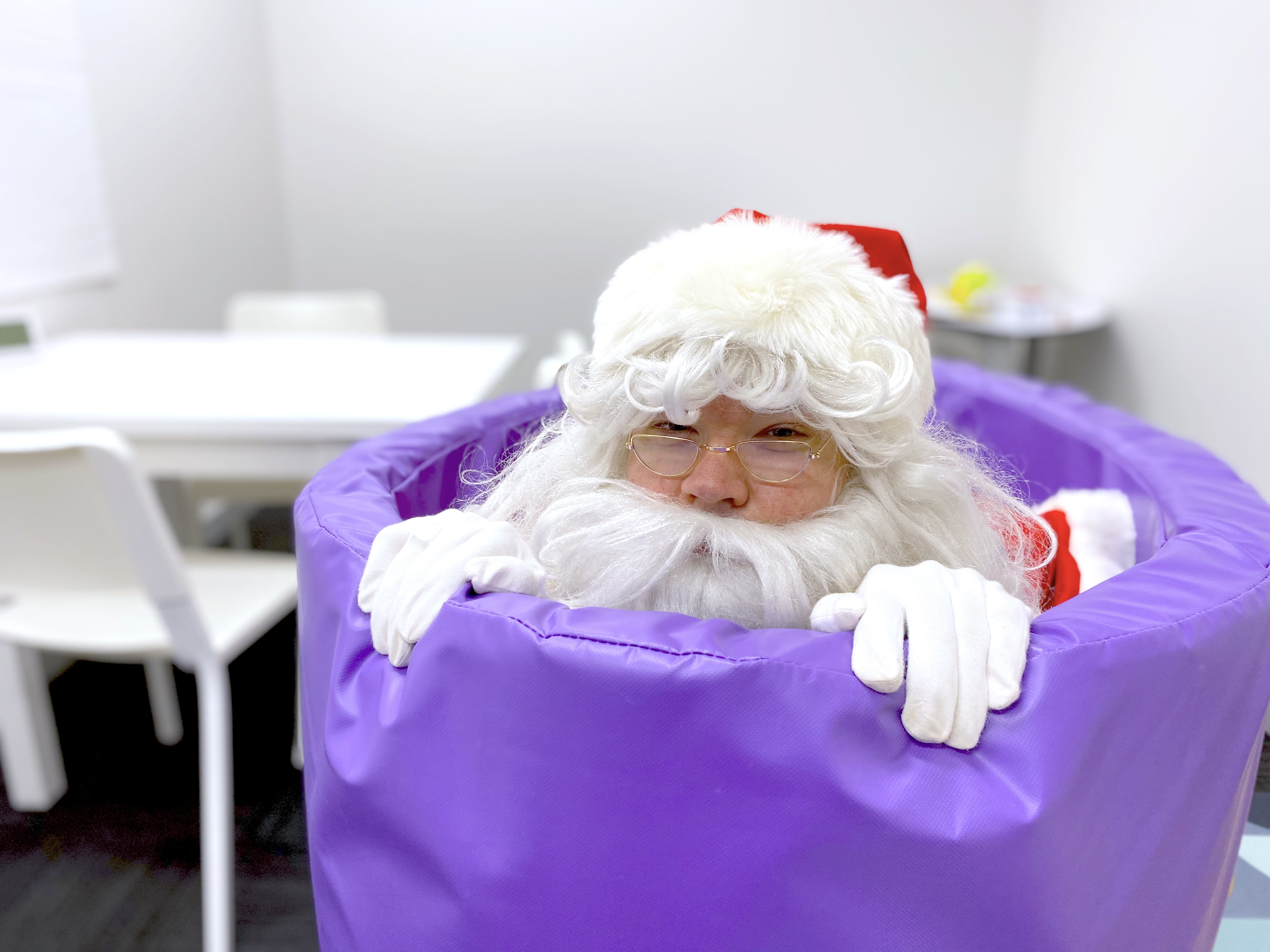 Santa's head popping out of a purple allied health therapy tube