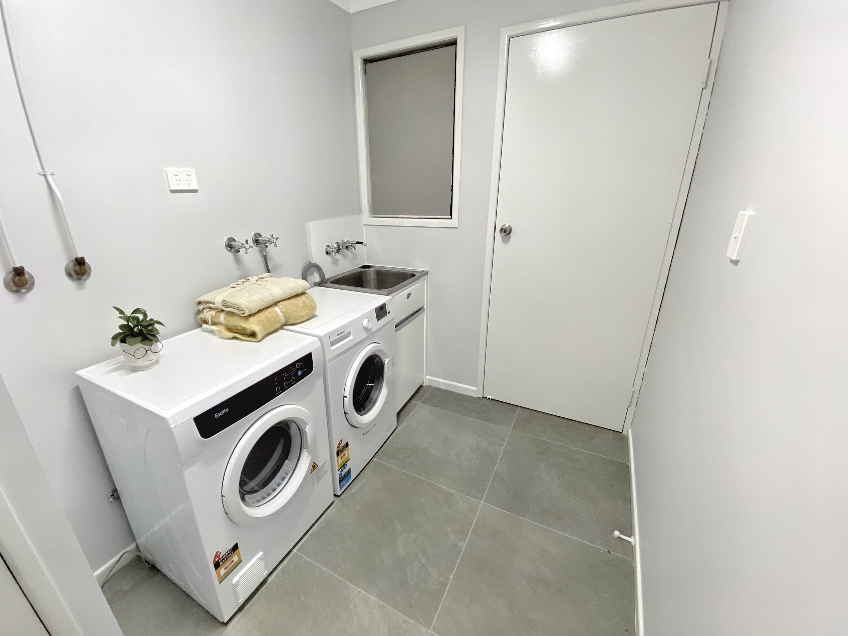 Laundry with a washing machine, clothes dryer and laundry basin..