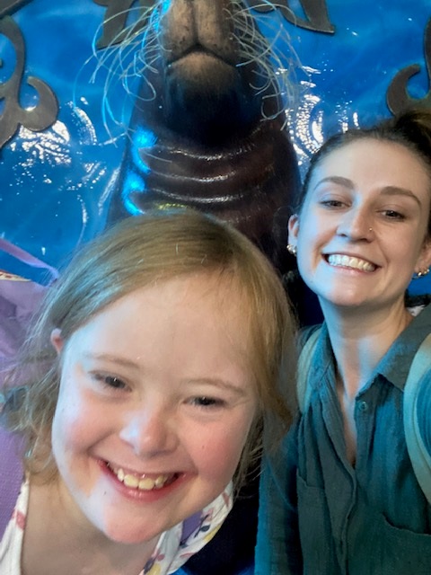 Rosie and Ash at Sea Life smiling in front of a seal statue