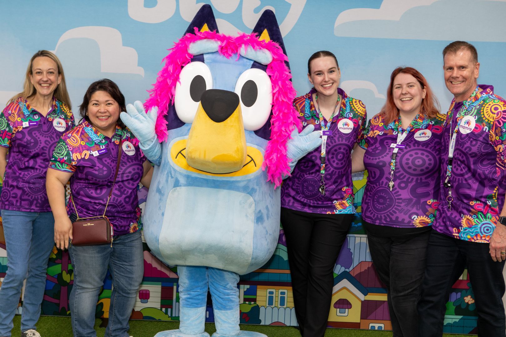 Mamre staff members group together for a photo with Bluey